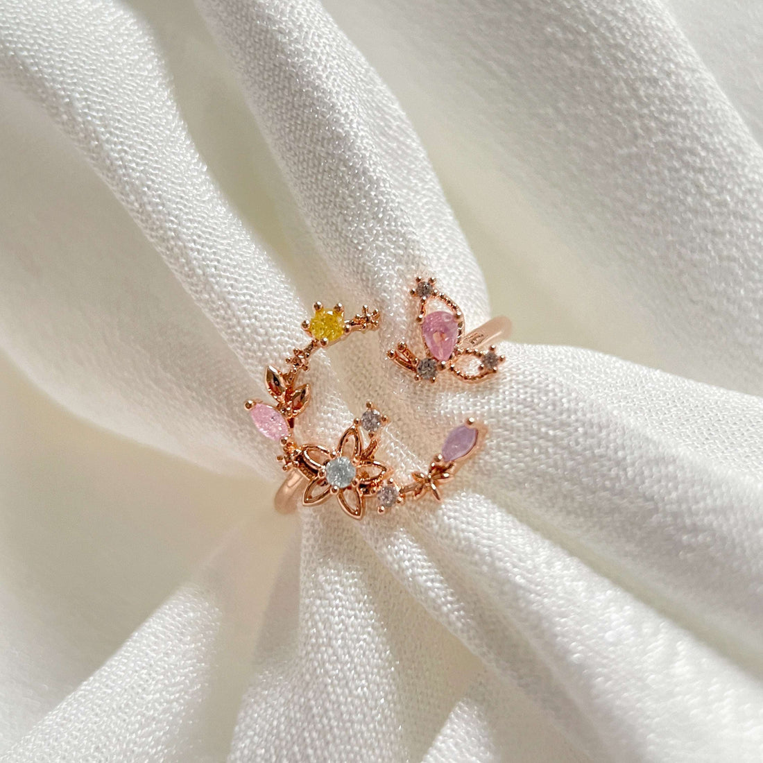 An adjustable rose gold everyday wear ring, with flower wreath in crescent shape adorned with a butterfly wing crafted with colorful gemstones - Sisilia Jewels