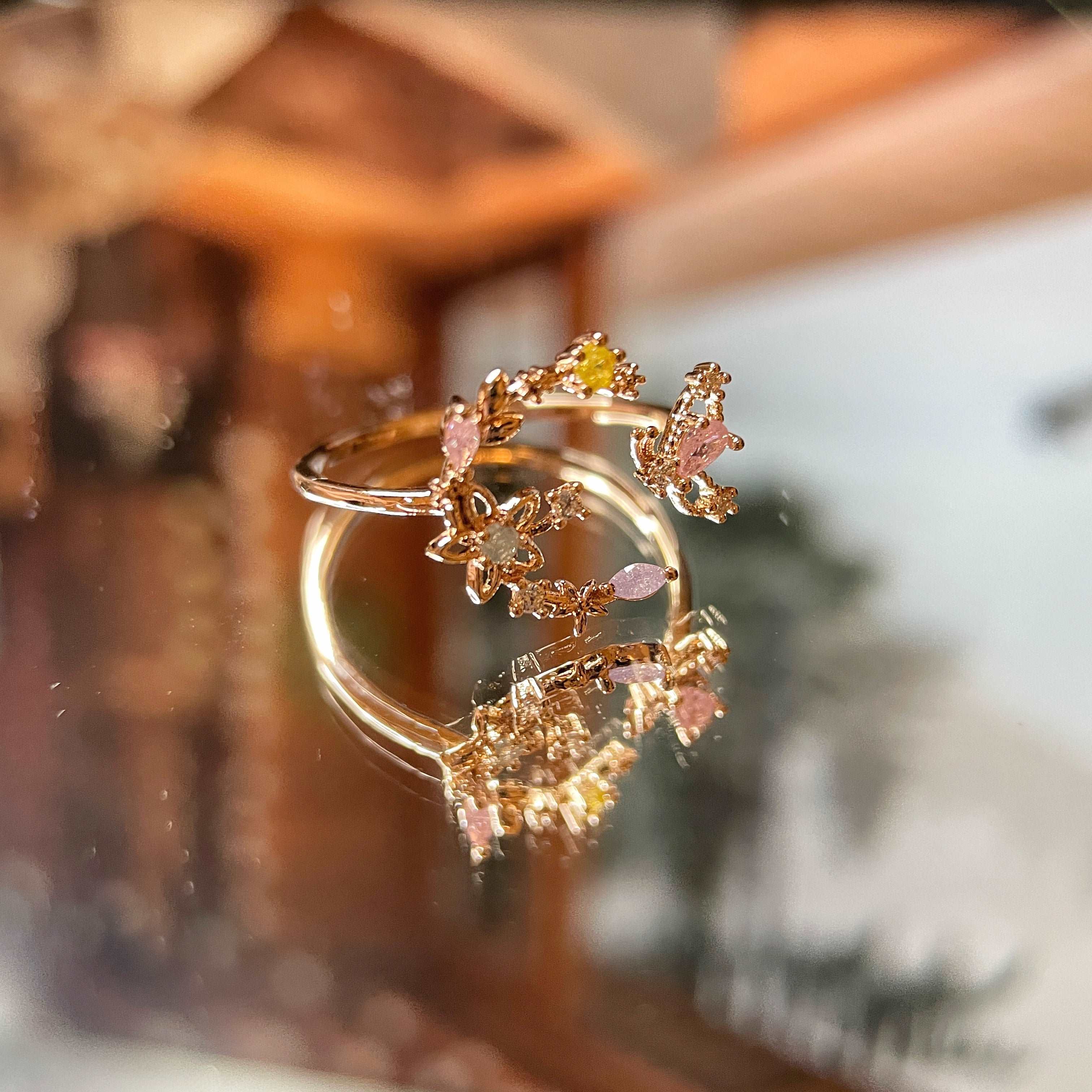 An adjustable rose gold everyday wear ring, with flower wreath in crescent shape adorned with a butterfly wing crafted with colorful gemstones - Sisilia Jewels