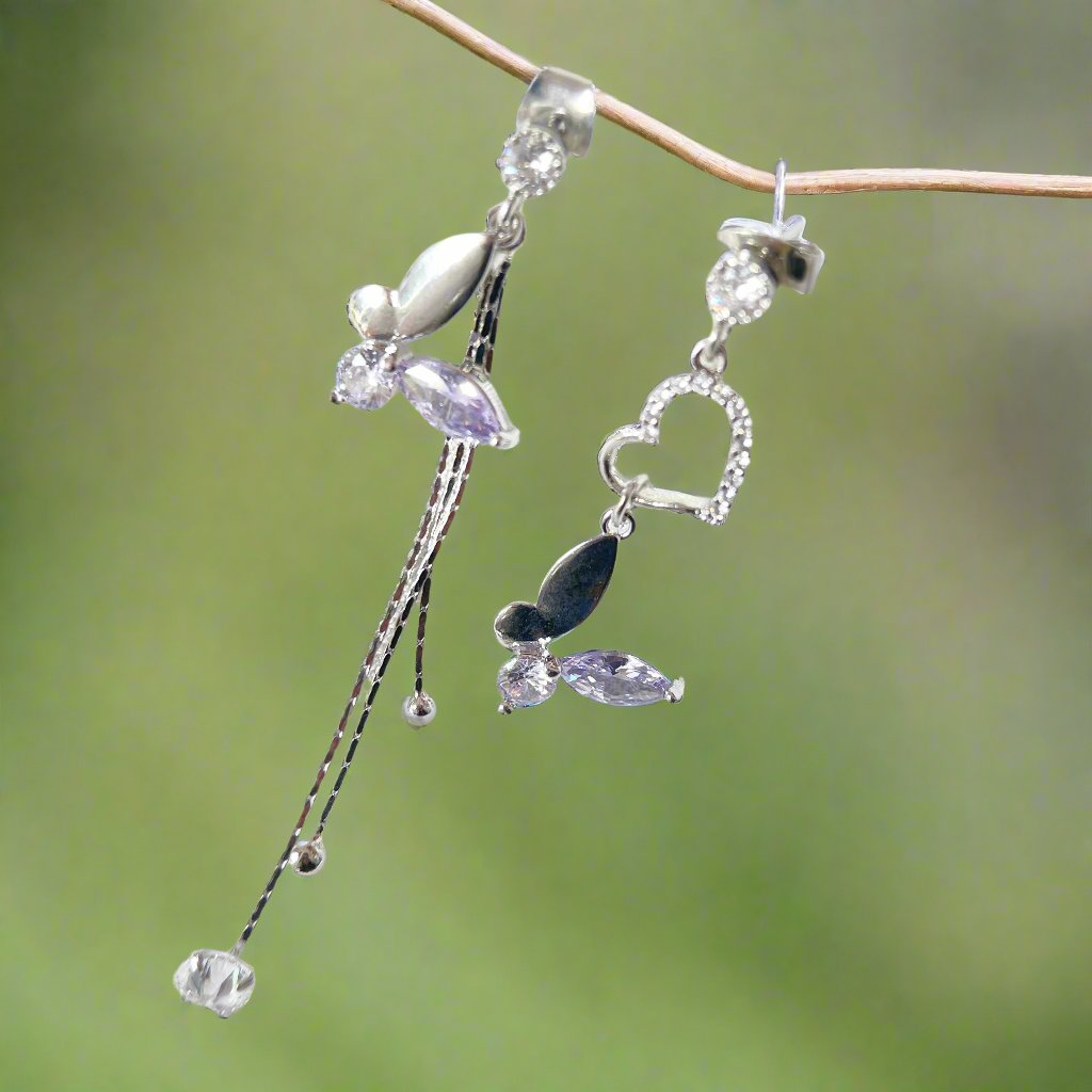 Pair of mismatched earring dangles in dream butterfly design crafted with semi-precious purple and colorless swarovski crystals, as well as a silver heart shape drops and two tassels drops - Sisilia Jewels